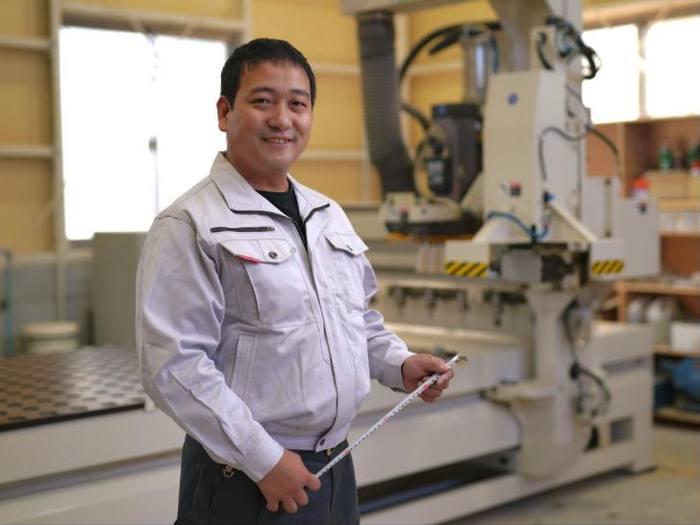 工場に立つ横山工房の代表